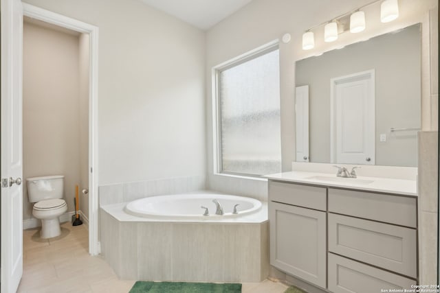 bathroom with vanity, a relaxing tiled tub, toilet, and tile patterned floors