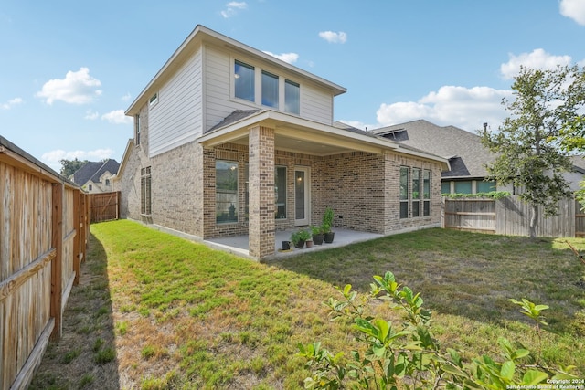 rear view of house with a yard and a patio area