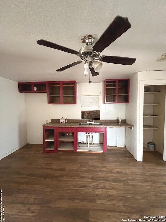 kitchen featuring a textured ceiling, ceiling fan, sink, and dark hardwood / wood-style flooring