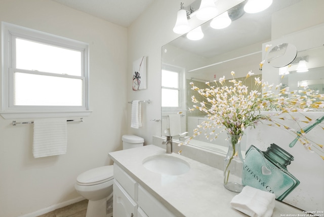 bathroom featuring tile patterned flooring, plenty of natural light, vanity, and toilet