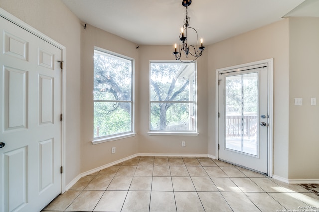 unfurnished dining area featuring light tile patterned floors, a chandelier, and a wealth of natural light