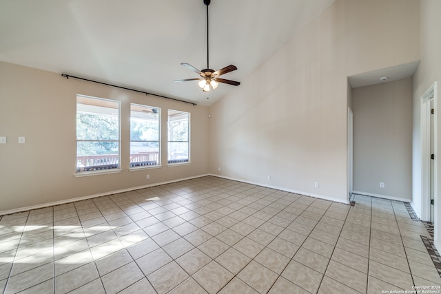 empty room with high vaulted ceiling, light tile patterned floors, and ceiling fan