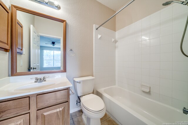 full bathroom featuring ceiling fan, tiled shower / bath, vanity, toilet, and tile patterned flooring