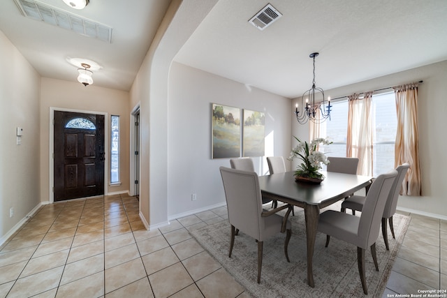 dining area featuring light tile patterned flooring and a notable chandelier