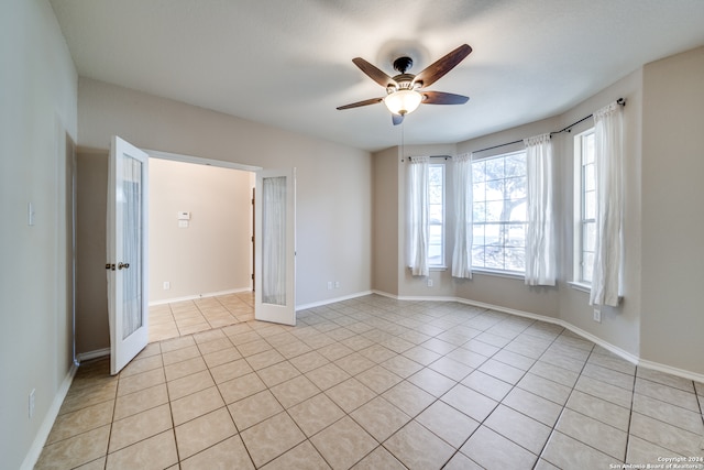 tiled spare room with ceiling fan and french doors