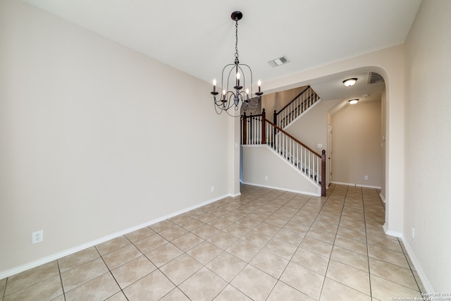 unfurnished room featuring light tile patterned flooring and a notable chandelier