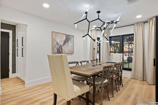 dining area with an inviting chandelier and light hardwood / wood-style floors