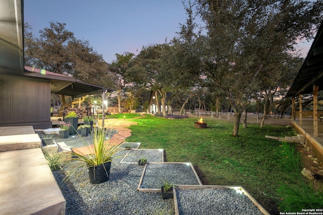 yard at dusk featuring a patio