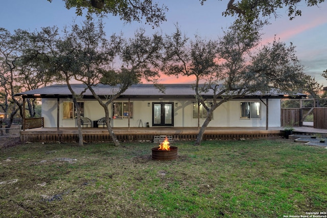 back house at dusk with a yard and a patio area