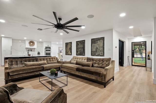 living room featuring ceiling fan and light wood-type flooring