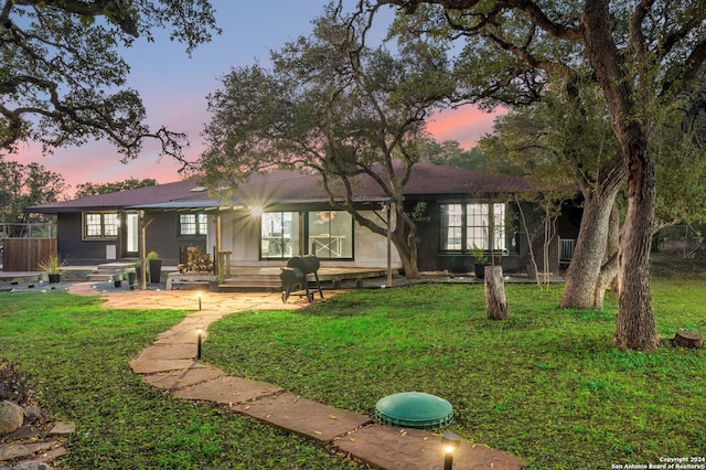 ranch-style home featuring a yard and a patio area