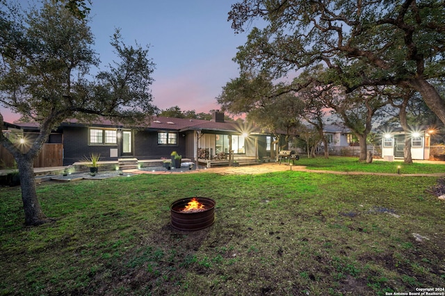 yard at dusk featuring a fire pit and a patio area