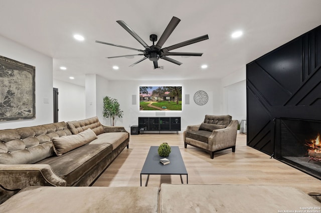 living room featuring light hardwood / wood-style flooring and ceiling fan