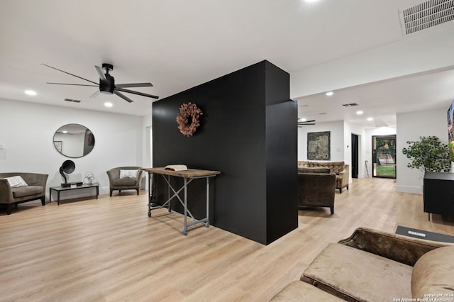 living room with light hardwood / wood-style flooring and ceiling fan