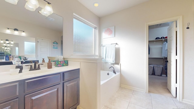 bathroom featuring tile patterned floors, vanity, and a bathing tub