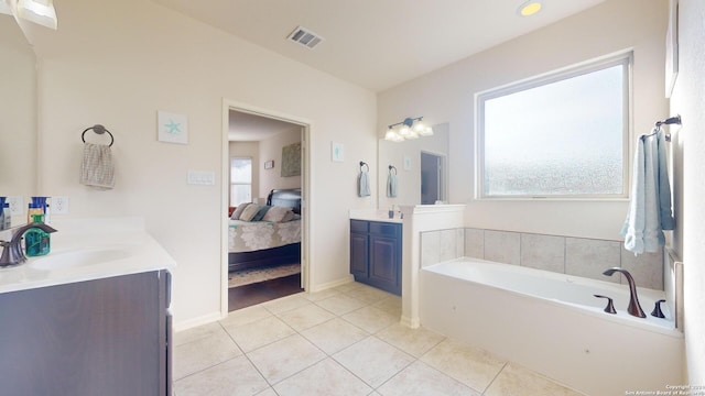 bathroom featuring a bath, tile patterned floors, plenty of natural light, and vanity