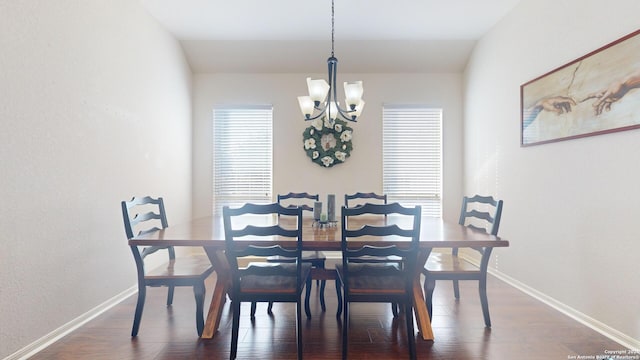 dining area featuring dark hardwood / wood-style floors, vaulted ceiling, and a notable chandelier