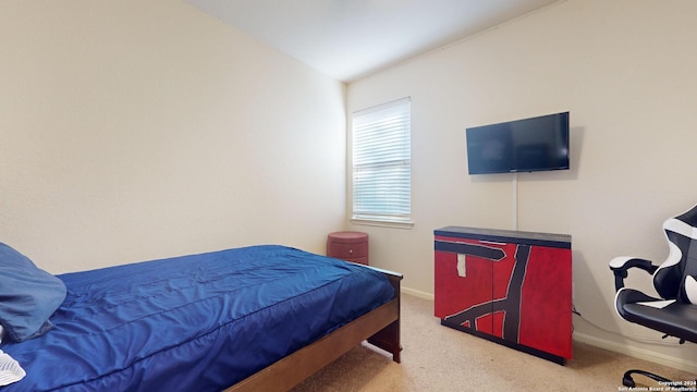 carpeted bedroom with lofted ceiling