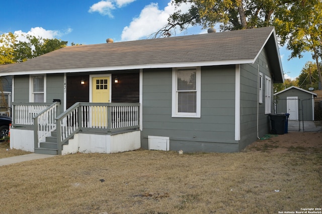 view of front of house with a front lawn and a shed