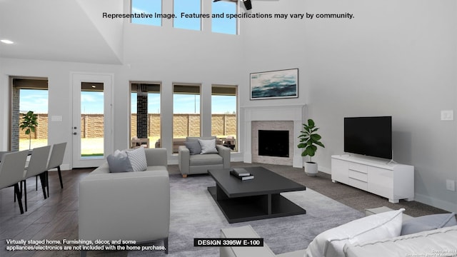 living room with ceiling fan, hardwood / wood-style floors, plenty of natural light, and a high ceiling