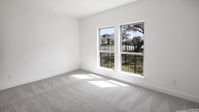 carpeted empty room with baseboards