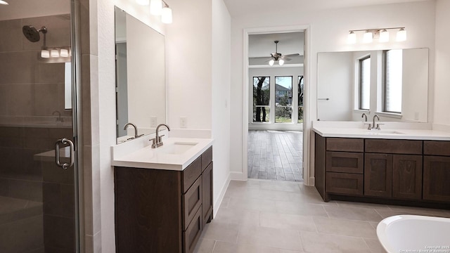 full bathroom featuring a stall shower, two vanities, and a sink