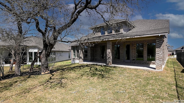 back of house featuring a patio, fence, a lawn, and brick siding