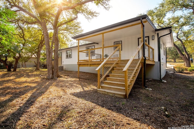 rear view of property featuring a wooden deck