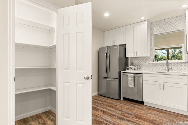 kitchen featuring sink, stainless steel appliances, dark wood-type flooring, and white cabinetry