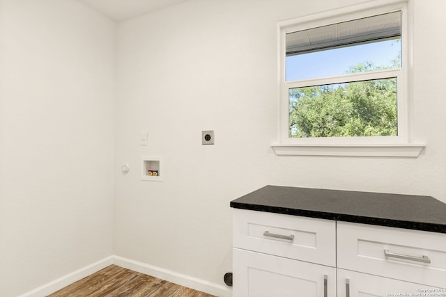 clothes washing area featuring light hardwood / wood-style floors, hookup for a washing machine, cabinets, and electric dryer hookup