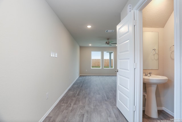 hallway with sink and wood-type flooring