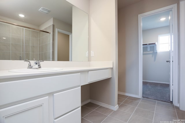 bathroom featuring vanity, tile patterned flooring, and tiled shower