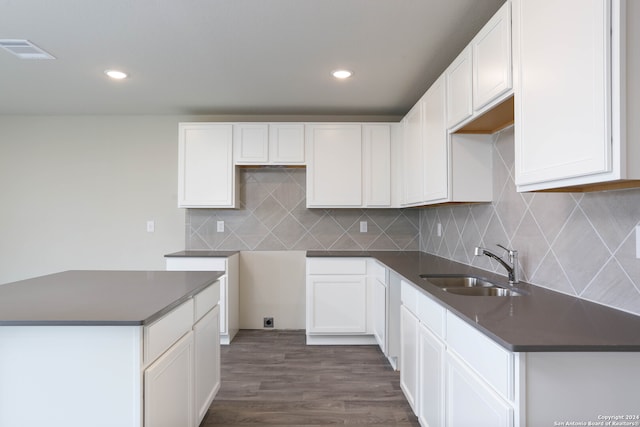 kitchen featuring white cabinets, sink, backsplash, and dark wood-type flooring