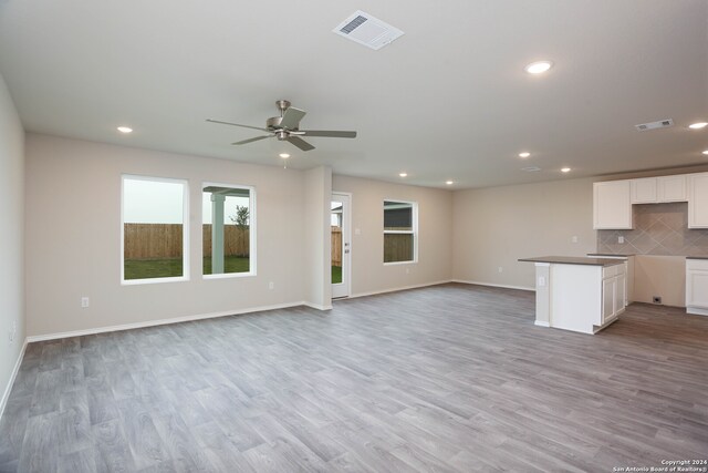 unfurnished living room with ceiling fan and light hardwood / wood-style flooring