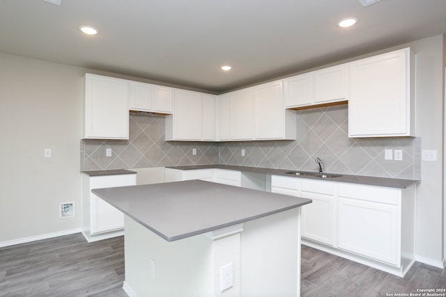 kitchen featuring white cabinets, hardwood / wood-style floors, sink, and a kitchen island