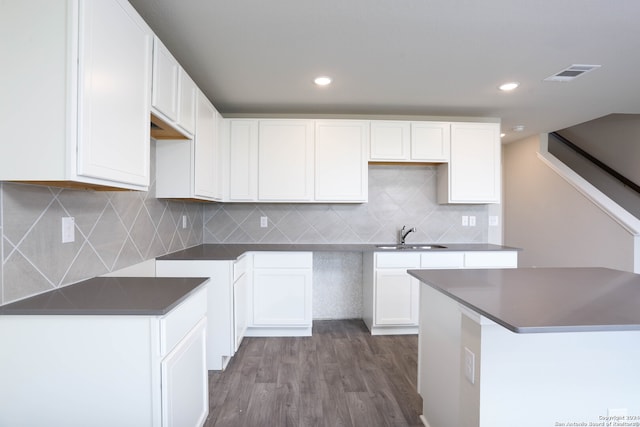 kitchen with dark hardwood / wood-style floors, sink, tasteful backsplash, and white cabinetry