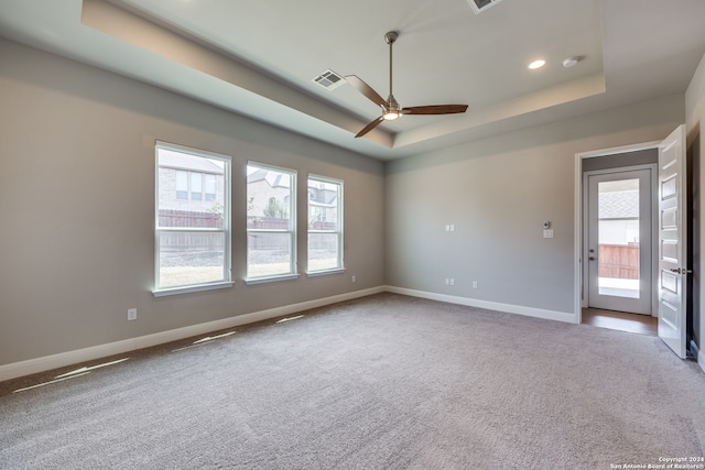 spare room featuring carpet floors, a raised ceiling, and ceiling fan