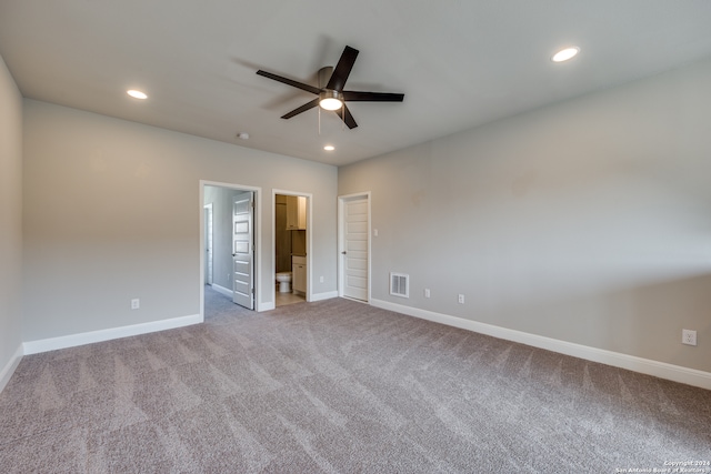 unfurnished bedroom with ceiling fan, light colored carpet, and ensuite bath