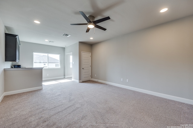 unfurnished living room featuring carpet flooring and ceiling fan