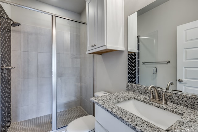 bathroom featuring vanity, an enclosed shower, and toilet