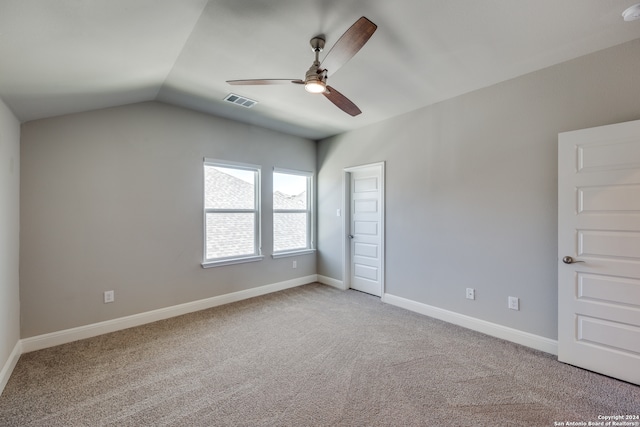 carpeted spare room with vaulted ceiling and ceiling fan