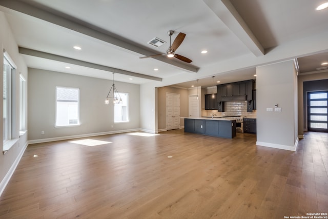 unfurnished living room with beam ceiling, light hardwood / wood-style flooring, and ceiling fan with notable chandelier