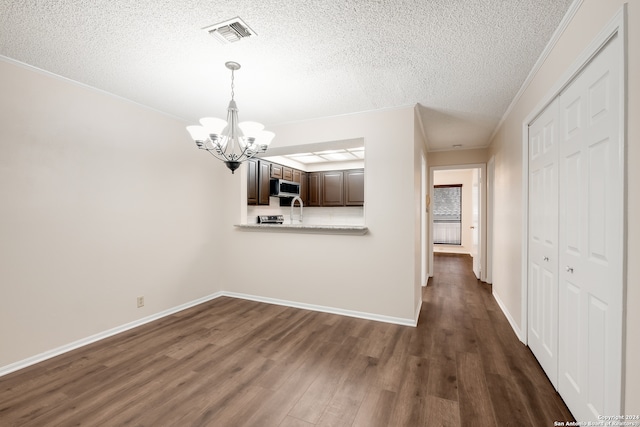 unfurnished dining area with dark wood-type flooring, crown molding, sink, and a textured ceiling