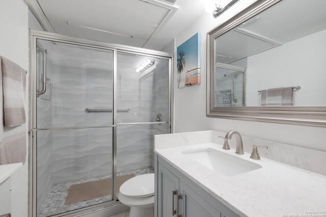 bathroom featuring vanity, toilet, and a shower with door