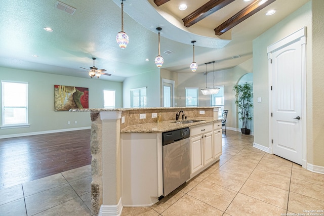 kitchen featuring an island with sink, beam ceiling, hanging light fixtures, and stainless steel dishwasher