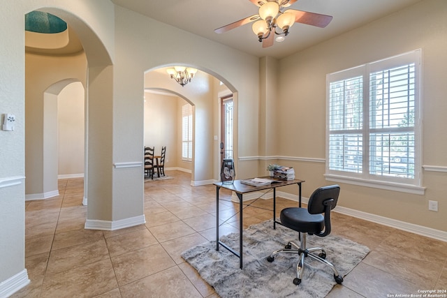 tiled office featuring ceiling fan with notable chandelier