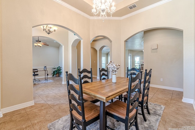 tiled dining space featuring ceiling fan with notable chandelier, ornamental molding, and a high ceiling