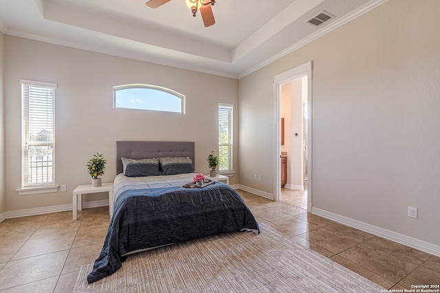 bedroom with ornamental molding, a tray ceiling, light tile patterned floors, and ceiling fan