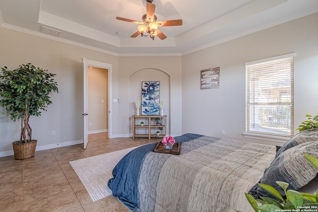 bedroom with ceiling fan, a raised ceiling, crown molding, and light tile patterned floors