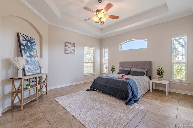 tiled bedroom with a raised ceiling, ornamental molding, and ceiling fan